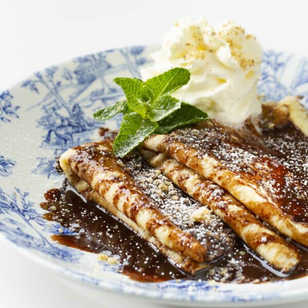 Chocolate pancakes with nuts and whipped cream