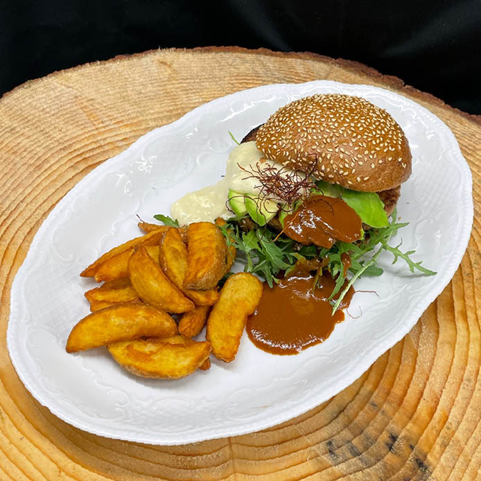Veggie Burger mit Avocado, Rucola, Schafkäsecreme, Wedges und ...